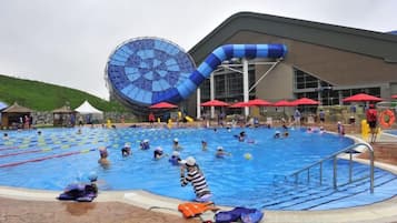 A swimming pool with multiple lanes, a large circular water feature, and a building with a modern design.