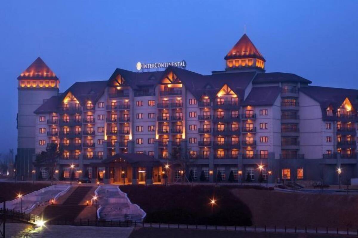 Ein mehrstöckiges Hotel mit markanter Architektur, das einen zentralen Turm und zahlreiche Balkone zeigt.