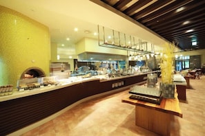 A modern hotel lobby with a curved reception desk, a large yellow textured wall, and a seating area with tables and chairs. - InterContinental ALPENSIA PYEONGCHANG RESORT by IHG (Pyeongchang-gun)