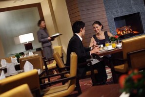 A restaurant setting with a fireplace, dining tables, and chairs. - InterContinental ALPENSIA PYEONGCHANG RESORT by IHG (Pyeongchang-gun)