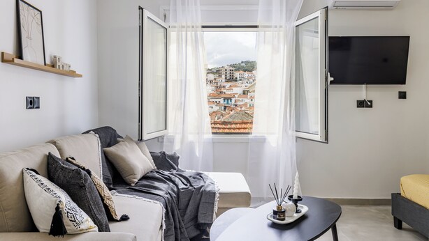 Un salon moderne avec un canapé, une table basse et un téléviseur fixé au mur.
