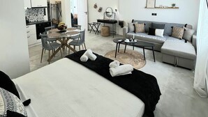 Une chambre d’hôtel moderne dotée d’un grand lit, d’un canapé, d’un coin repas et d’une cuisine.