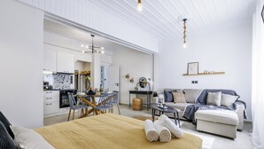 Une pièce moderne et bien éclairée, comprenant un lit, un canapé, un coin repas et une cuisine.