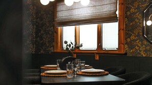 A dining table set with plates, glasses, and a vase of flowers. - Obies Abode: Newly Renovated (Pittsburgh)