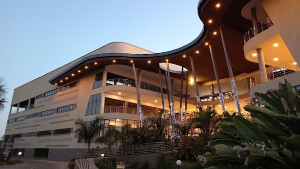 Un hôtel moderne à plusieurs étages, doté de balcons et d’un atrium central.