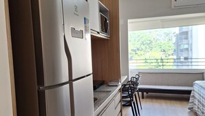Et moderne køkken med et rustfrit stål køleskab, træskabe og en indbygget mikroovn.