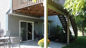 A covered patio with outdoor furniture, a staircase, and a door leading to a garage. - Spacious 4-bedroom house with AC, WiFi in NW Lincoln (Lincoln)