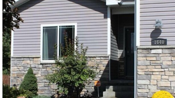 A single-story house with a stone foundation, a front porch, and a mailbox. - Spacious 4-bedroom house with AC, WiFi in NW Lincoln (Lincoln)