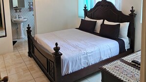Ein Schlafzimmer mit einem großen Bett, einer Deckenleuchte, einem Nachttisch und einem Spiegel.