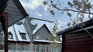A residential area with a swimming pool, a wooden shed, and houses with snow-covered roofs. - 2 Bedroom at Mystic Springs Chalets & Hot Pools (Canmore)