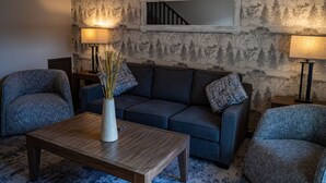 A living room with a sofa, two armchairs, a coffee table, and two floor lamps. - 2 Bedroom at Mystic Springs Chalets & Hot Pools (Canmore)