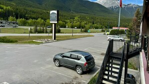 Ein Parkplatz mit einem Schild für Yamnuska Suites, einem Berg im Hintergrund und einer Flagge.