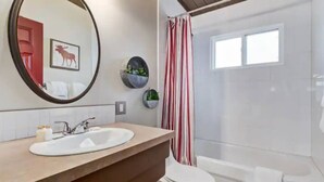 Un bagno con lavandino, WC e doccia.