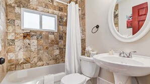 A bathroom with a bathtub, toilet, and sink.