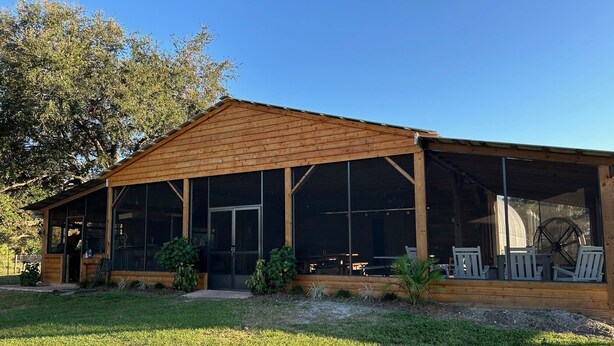 A wooden building with a covered porch and large windows.
