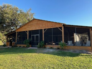 A wooden building with a covered porch and large windows. - Farmstay Event Space with 2 Houses on 15 Acres with Additional Amentities Avail (Indiantown)