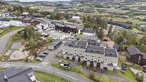 A large building complex with multiple buildings, parking areas, and a road curving around the property. - Apartment near Oslo, Drammen, and a lake (Buskerud)