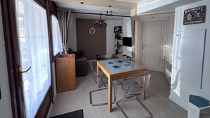 A compact living space with a dining table, a sofa, a television, and a door. - Apartment 4 Adults and one child - Flumet - heated swimming pool (Flumet)