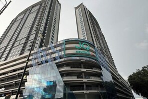 Een hoog gebouw met een gebogen gevel en een bord waarop 'JG CENTRAL' staat.