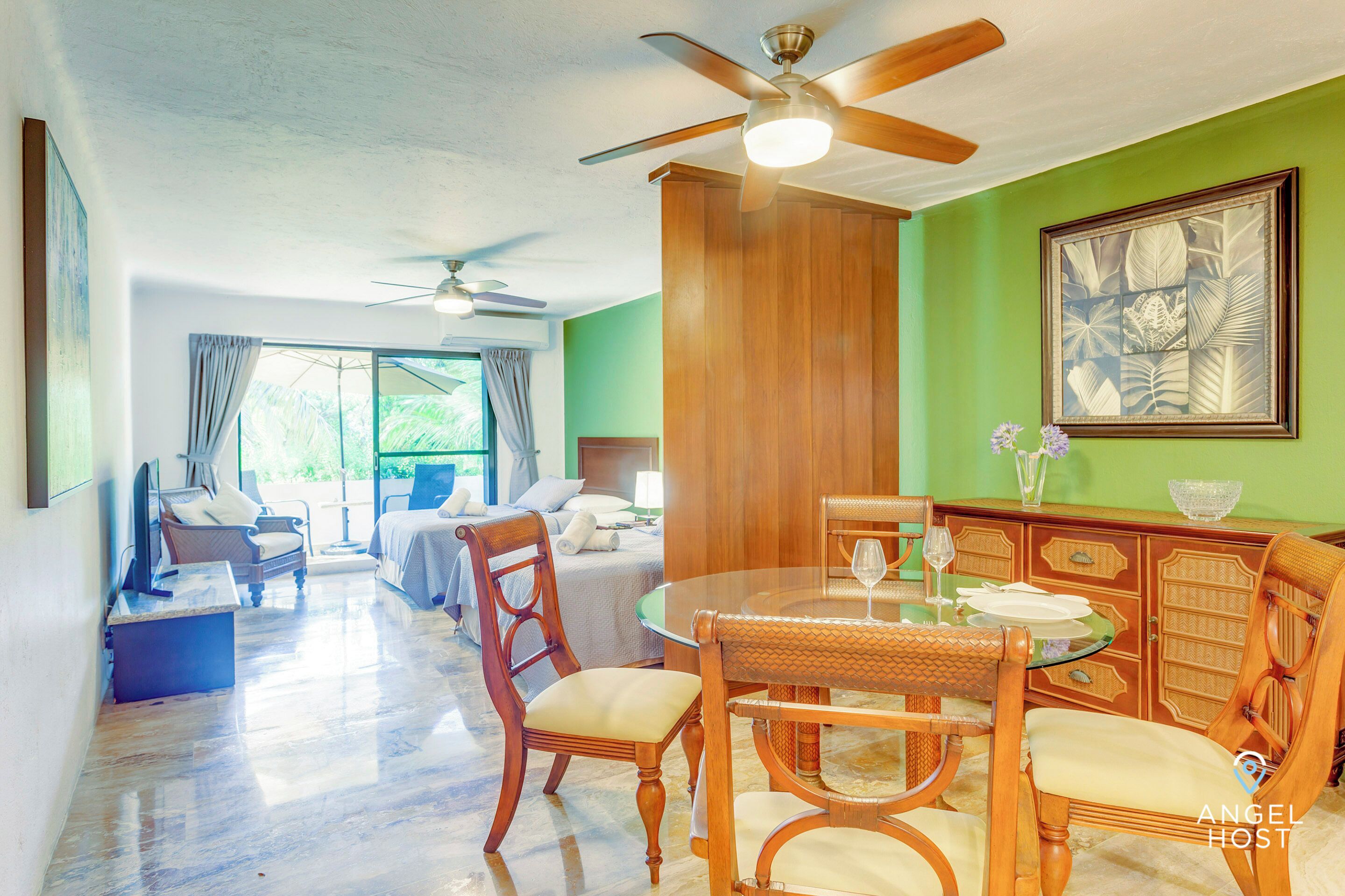 Une chambre d’hôtel avec un coin repas, un lit et une grande fenêtre.