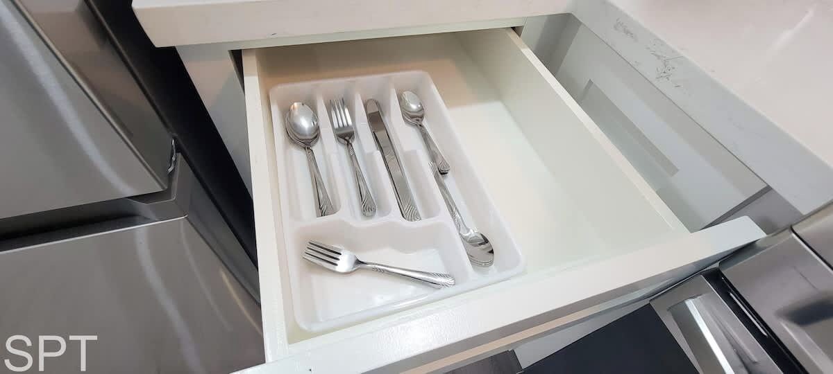 A drawer with neatly arranged cutlery including forks, knives, and spoons.