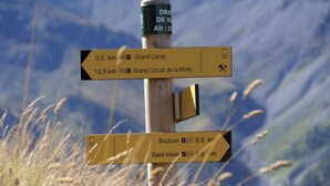 A directional signpost with multiple arrows pointing towards different destinations, including distances and directions. - CASA-Mezan, appartement cosy 2 chambres (Aiguilles)