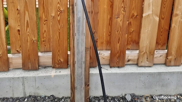 A wooden fence with a charging station attached to it. - CASA-Mezan, appartement cosy 2 chambres (Aiguilles)