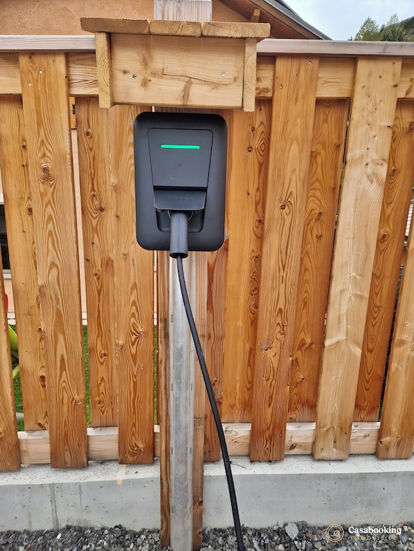 A wooden fence with a charging station attached to it. - CASA-Mezan, appartement cosy 2 chambres (Aiguilles)