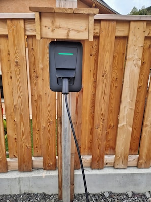 A wooden fence with a charging station mounted on it. - CASA-Mezan, appartement cosy 2 chambres (Aiguilles)