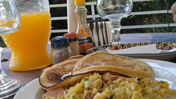 A breakfast setting with toast, scrambled eggs, and orange juice on a table.