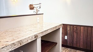 A modern kitchen with a granite countertop, wooden cabinets, and a hanging decorative item. - Room-luxurious Lodge Room 2 (Beberibe)