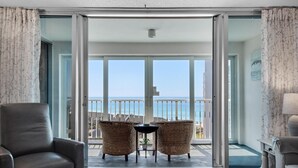 A balcony with a view of the sea, furnished with wicker chairs and a table. - Shoreline Towers 3094 (Destin)