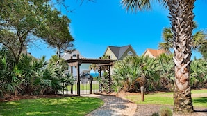 A garden pathway leading to a gazebo, surrounded by lush greenery and palm trees. - Beach Resort 514 (Miramar Beach)