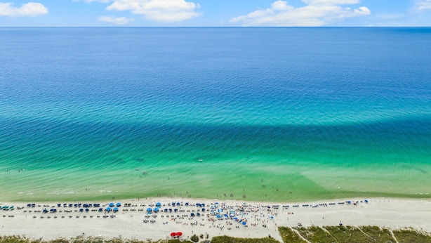 Ein Strand mit klarem, türkisblauem Wasser und einem Sandstrand.