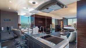 Una habitación de hotel moderna con cocina, una mesa de comedor y un sofá.