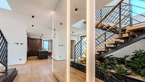 A modern interior with a wooden staircase, a hallway with a wooden floor, and a view of the outdoors through a large window. - Luxury Villa Waterlily with Pool (Vodice)
