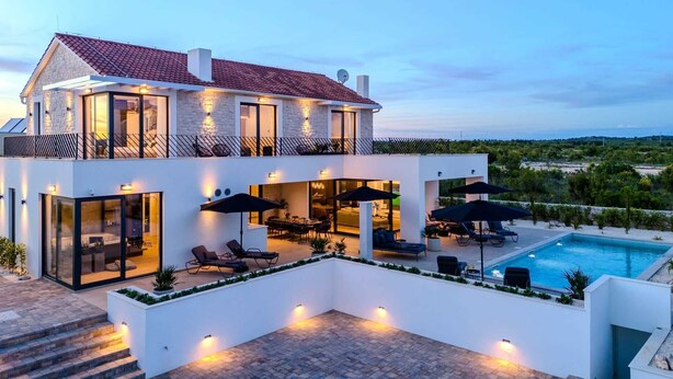 A modern two-story house with a swimming pool, outdoor seating, and a view of the landscape. - Luxury Villa Waterlily with Pool (Vodice)