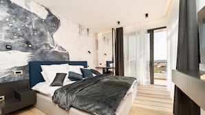 A modern bedroom with a bed, bedside tables, a TV, and a balcony with curtains. - Luxury Villa Waterlily with Pool (Vodice)