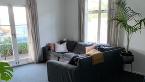 Un salon moderne avec un canapé gris, une table basse et une plante en pot.