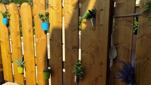 Una valla de madera con múltiples macetas sujetas a diferentes alturas.