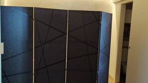 Una habitación con un separador de color oscuro y estampado geométrico.