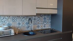 Una cocina de diseño moderno, con horno empotrado y pileta con grifo.