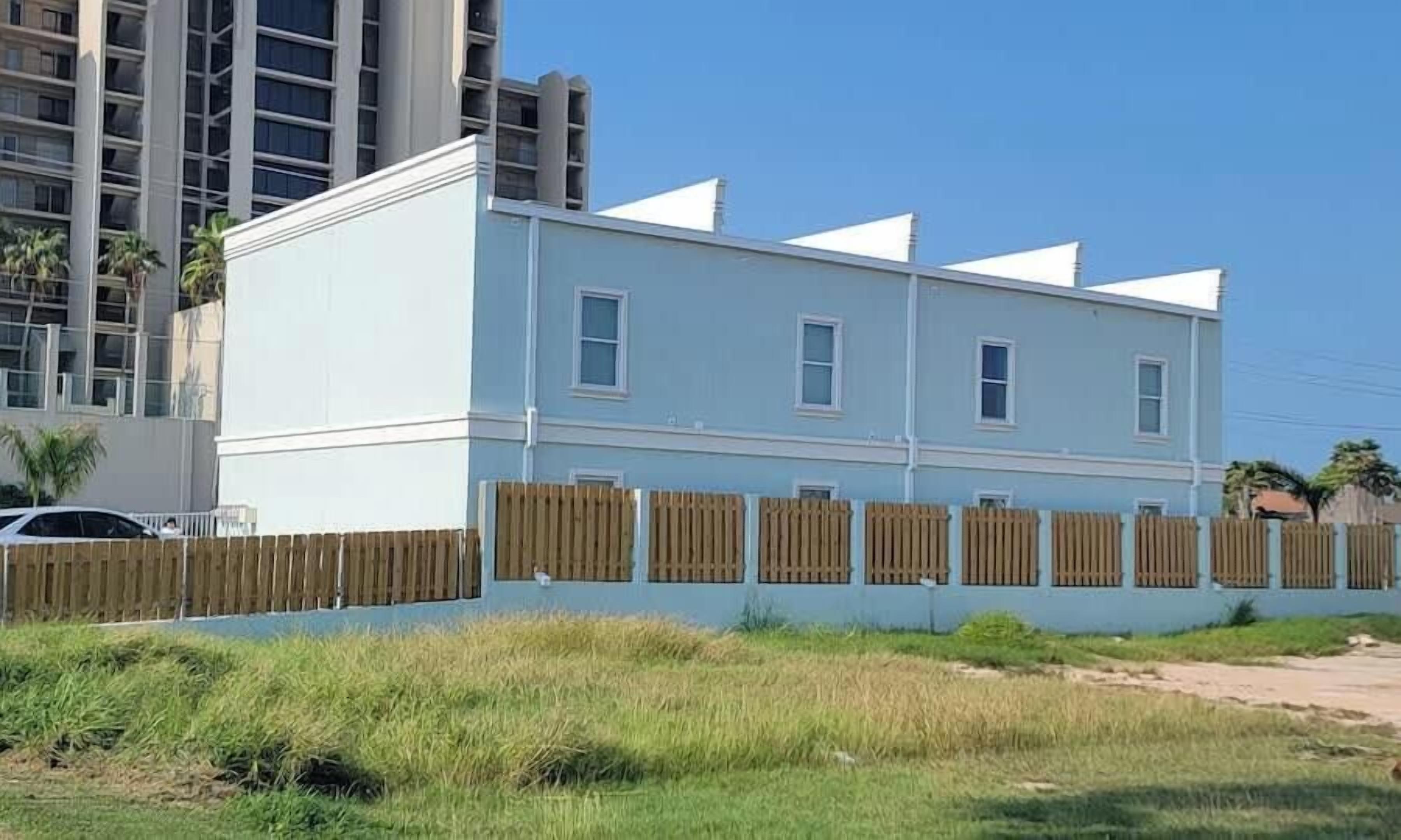 A two-story building with a flat roof and a white exterior.