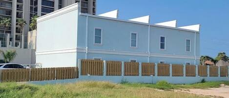 A two-story building with a flat roof and a white exterior.