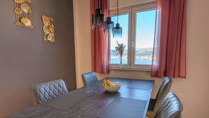Ein Essbereich mit einem langen Tisch, gepolsterten Stühlen und einer Bananenschale.