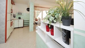 Una cocina con comedor, un reloj y una planta en maceta.