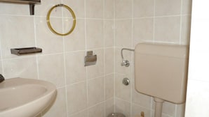 Une salle de bain avec un lavabo, des toilettes et un porte-serviettes.