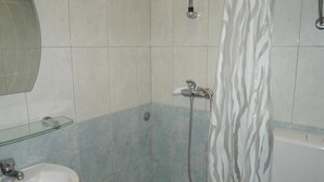 A bathroom with a shower, a sink, and a toilet.
