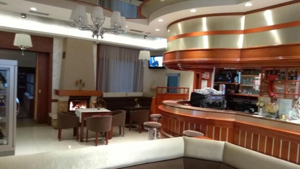 Un interno moderno con un'area bar a forma di arco, posti a sedere e un camino.