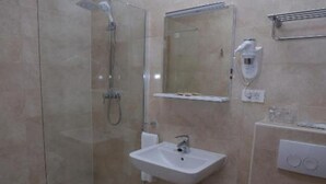 A modern bathroom with a glass-enclosed shower, a sink, and a mirror. - Hotel Orion - Single Room with Mountain View (Ivanec)